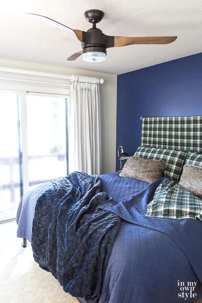 Navy-blue-accent-wall-in-bedroom with popcorn texture on ceilings.