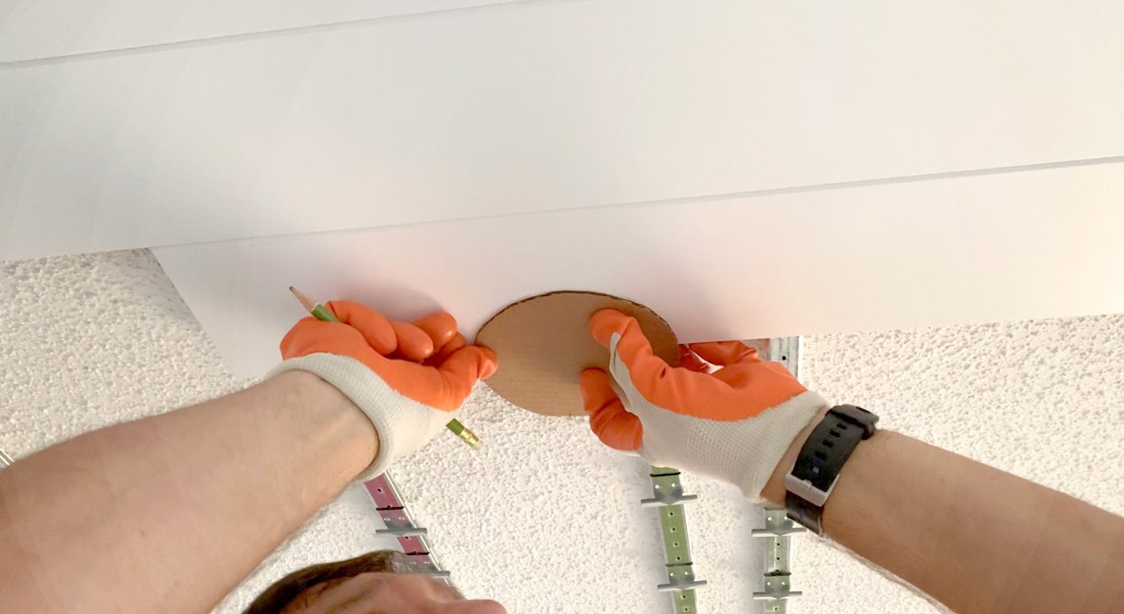 How to make and use a cardboard template to cut out where ceiling light fixtures will go when installing a new ceiling over an existing one.