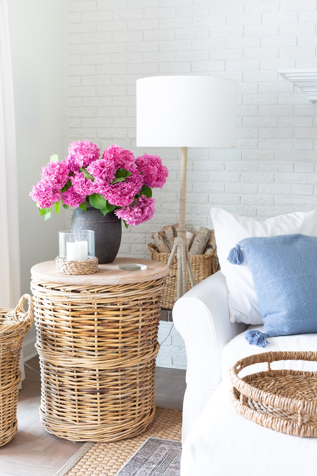 white and blue living room with pink hydrangeas in a black planter