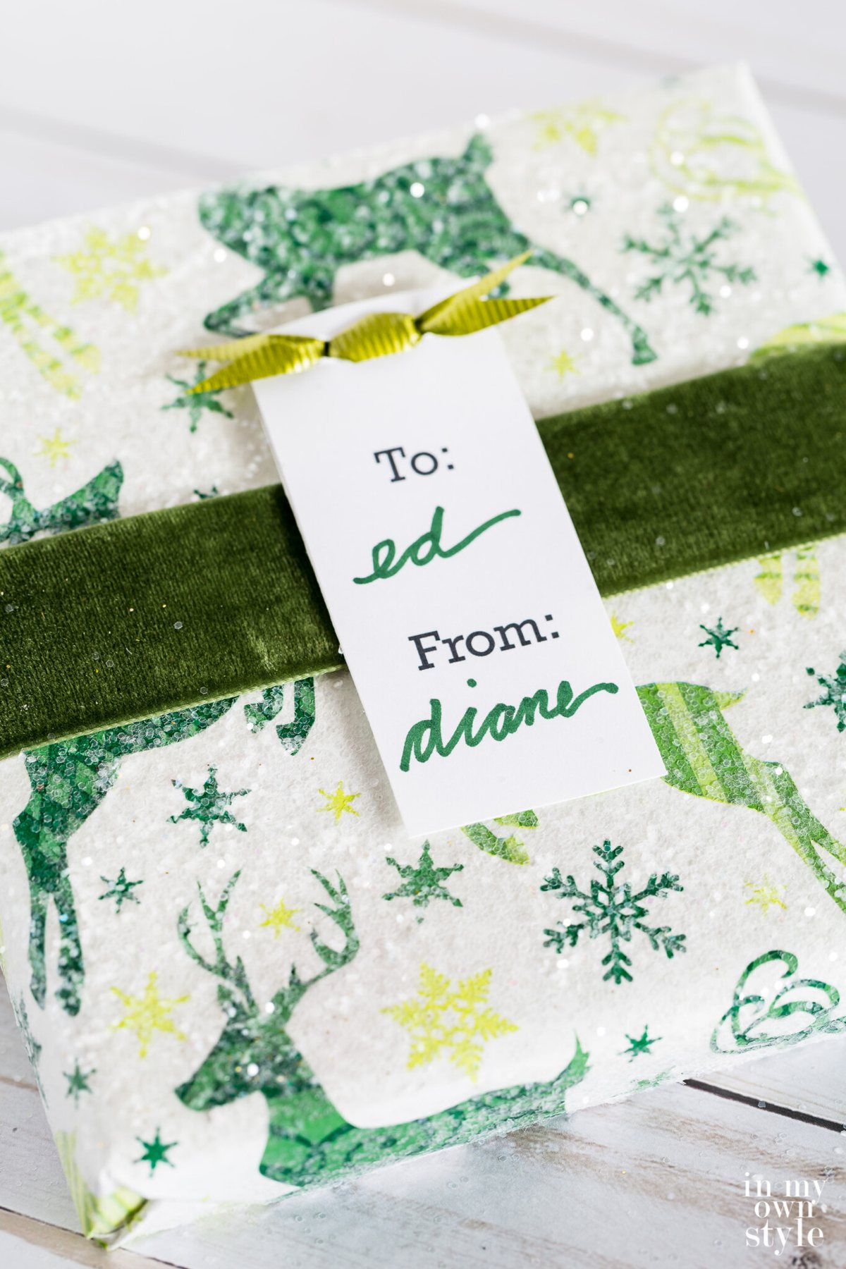 White and green wrapped gift for Christmas sprinkled with glitter