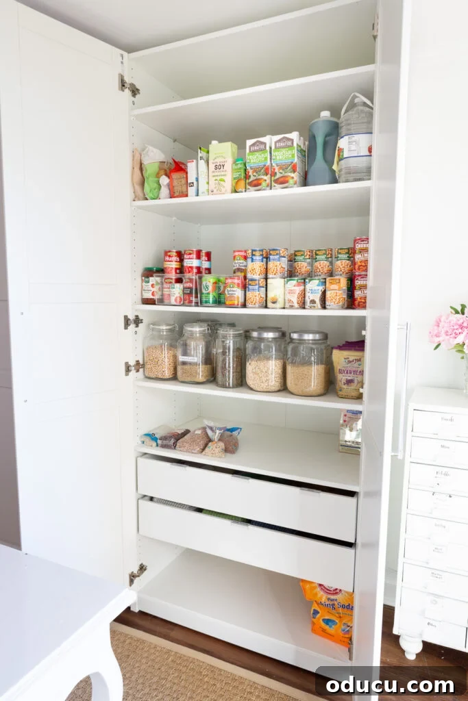 From Spare to Stellar: Room Transformation 8 IKEA PAX storage closet in white fitted with shelves and 2 drawers to hold food and pantry staples in a multi-purpose room in a home.