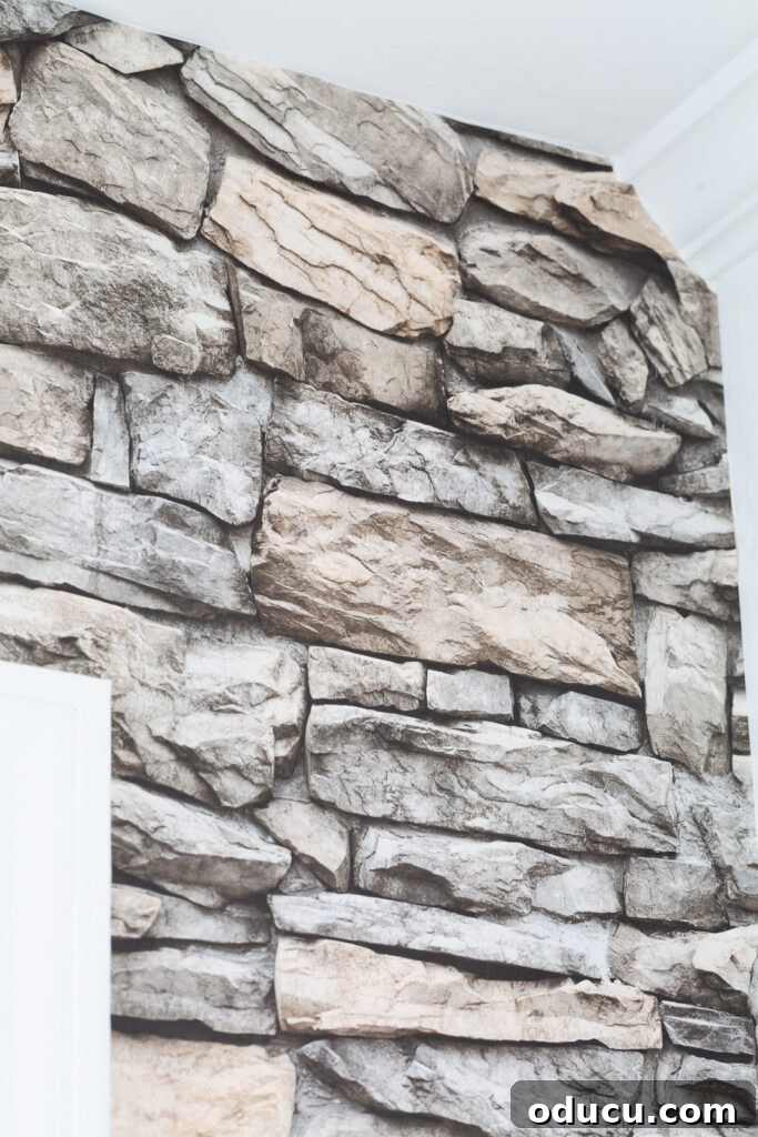 Unveiling Our Open Kitchen Wall 12 A detailed close-up of the faux stone wallpaper on the kitchen's accent wall, showcasing its realistic texture and depth, proving its visual appeal.