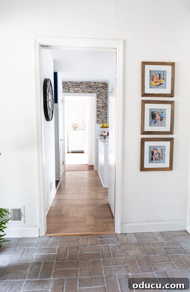 Unveiling Our Open Kitchen Wall 7 The captivating view of the kitchen from the foyer, featuring an accent wall adorned with faux stacked stone wallpaper, drawing the eye inward.