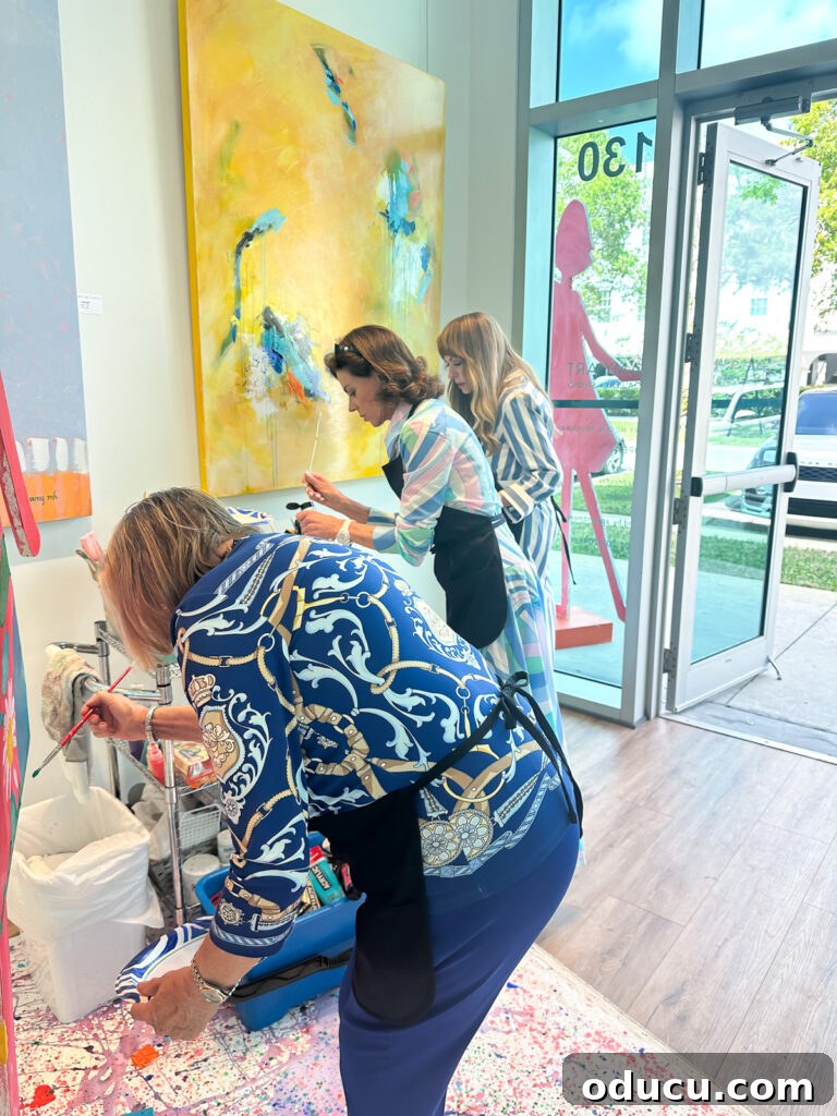 Unlock Your Decor Potential with Craft Paint 5 Women engage in a fun painting activity, decorating a paper doll sculpture at a vibrant charity event held in an Art Gallery.