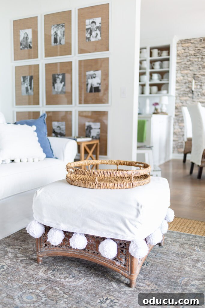 Round rattan tray on white slipcovered ottoman in a living room.