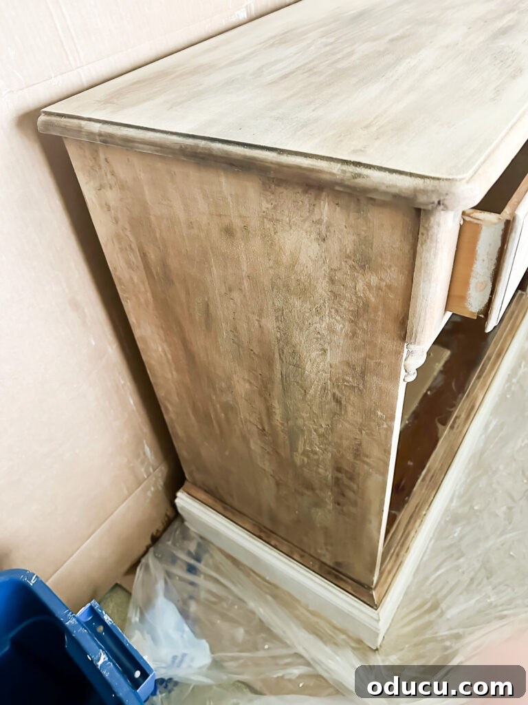 The Transformed Cabinets 2 side of stripped piece of wood furniture, appearing spotty and grey after paint removal