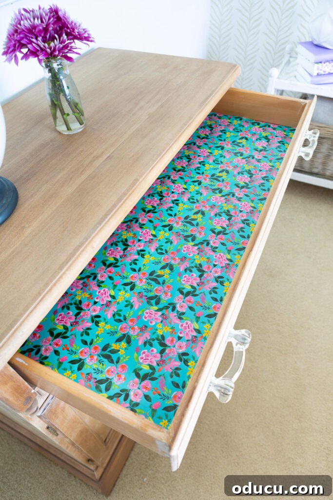 The Transformed Cabinets 13 Lining a drawer with vibrant floral gift wrap, adding a pop of color and unexpected charm to the cabinet