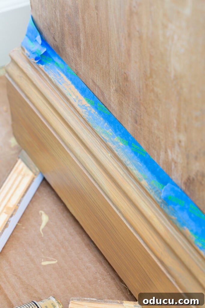 The Transformed Cabinets 9 Applying brown glaze over yellow base, then dragging a clean brush to create first layer of faux wood grain