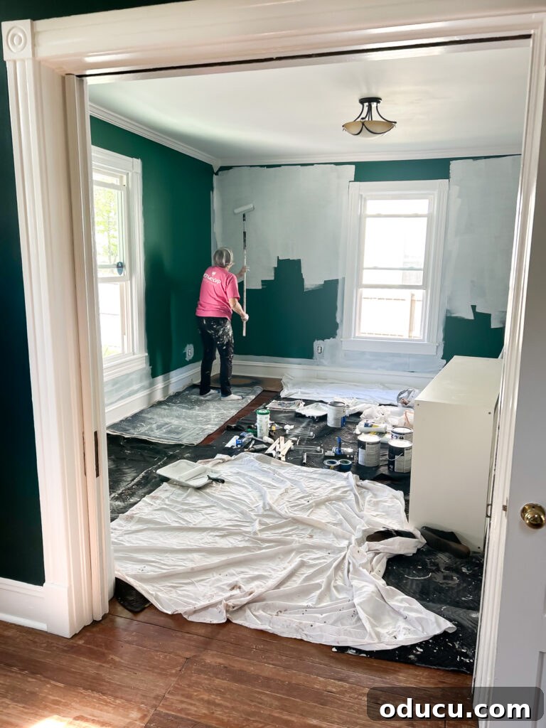 Painting light color paint over dark in a home, showcasing the process.