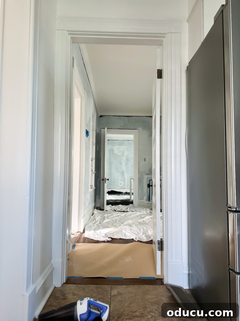 View of the first floor from the kitchen, showcasing painting progress.