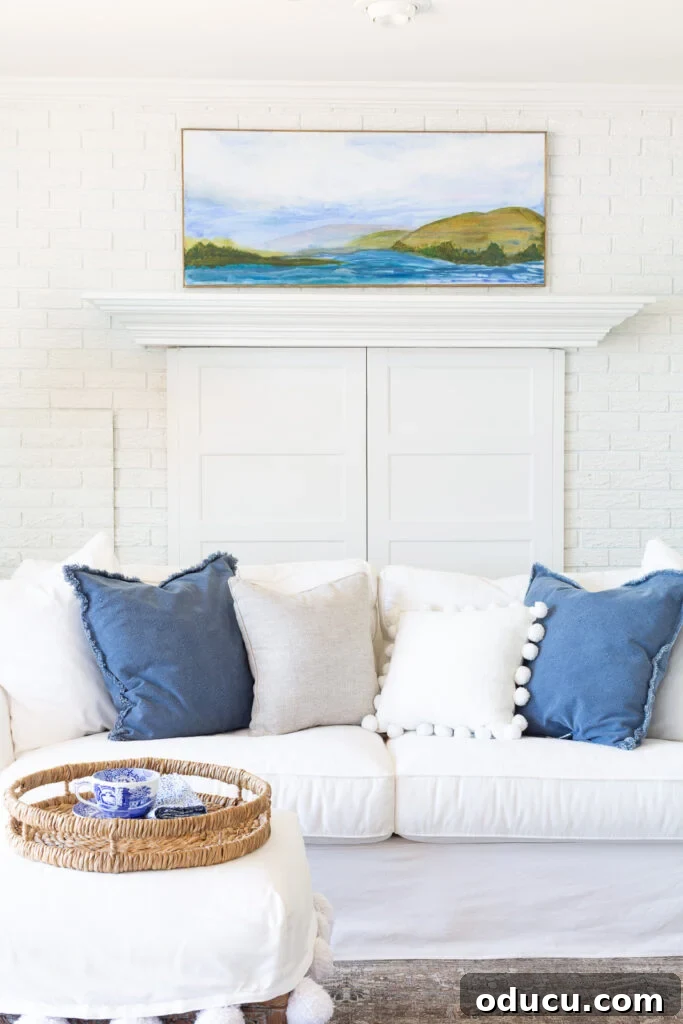 A tranquil blue and white living room featuring custom-made wall art, reflecting a modern coastal vibe.