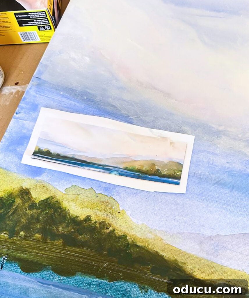 A printed watercolor of water and mountains, serving as color and image inspiration for a DIY acrylic art canvas.