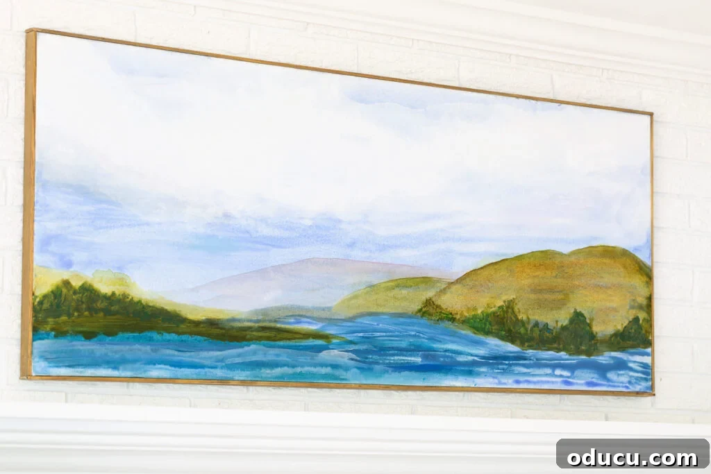 A finished, framed, and proudly hung art canvas featuring a tranquil water and mountain scene, now gracing the living room wall.