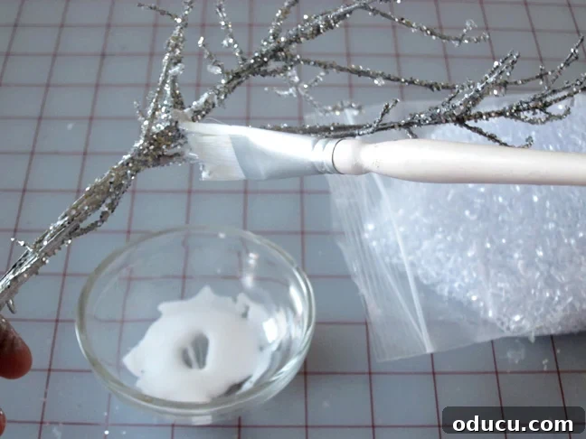 Applying white glue for an icy build-up effect How to make snowy looking branches for holiday decor