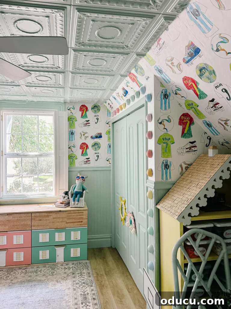 Style Scout 245 2 A charming kids room featuring a whimsical wallpaper created from children's artwork, showcasing vibrant colors and unique designs perfect for a playful nursery or bedroom.