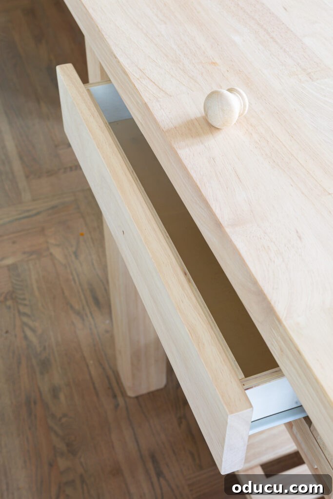 My Kitchen's New Centerpiece 7 A detailed close-up of the smooth wooden drawer integrated into the new kitchen island, prior to its planned painting with Sherwin Williams Emerald paint.