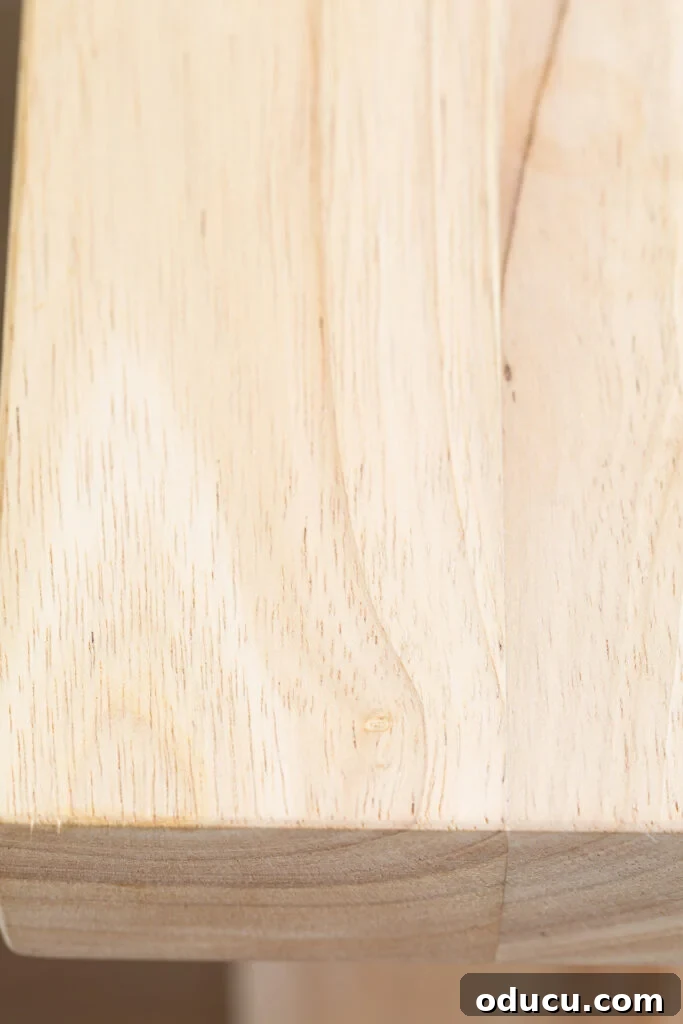 My Kitchen's New Centerpiece 10 A close-up view of the natural wood grain on the kitchen island's top surface, prepared for its protective finish, possibly with Polycrylic Max.