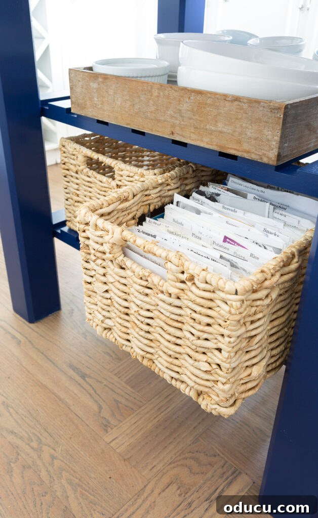 A basket on the kitchen island's bottom shelf, pulled out to reveal its function as a stylish recipe box.