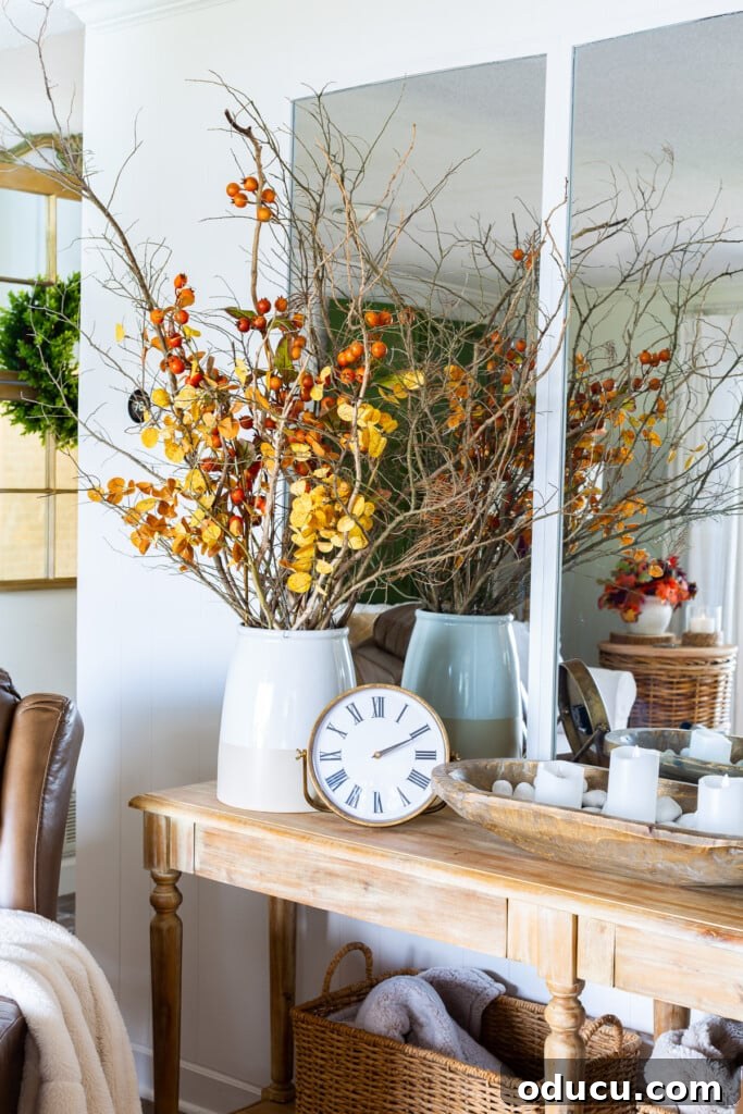 Fall Decor Reimagined 26 Bare wood sideboard with dried leaves and branches in large planter.