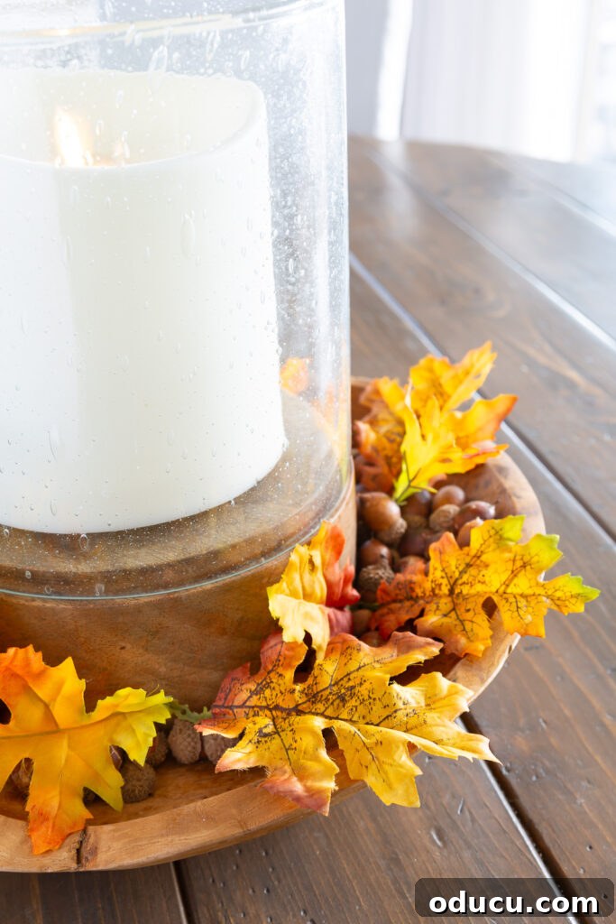 Fall Decor Reimagined 27 single faux fall leaves around a candle in a wood bowl