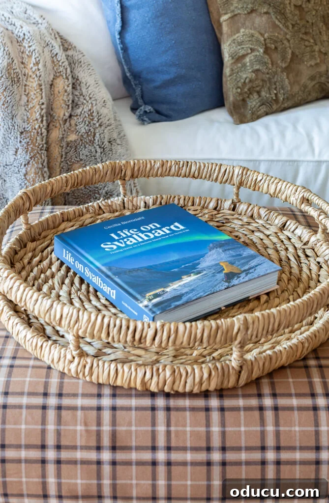 Remember That Essential Decorating Resource 13 round woven tray with a blue coffee table book on with the title Life on Svalbard