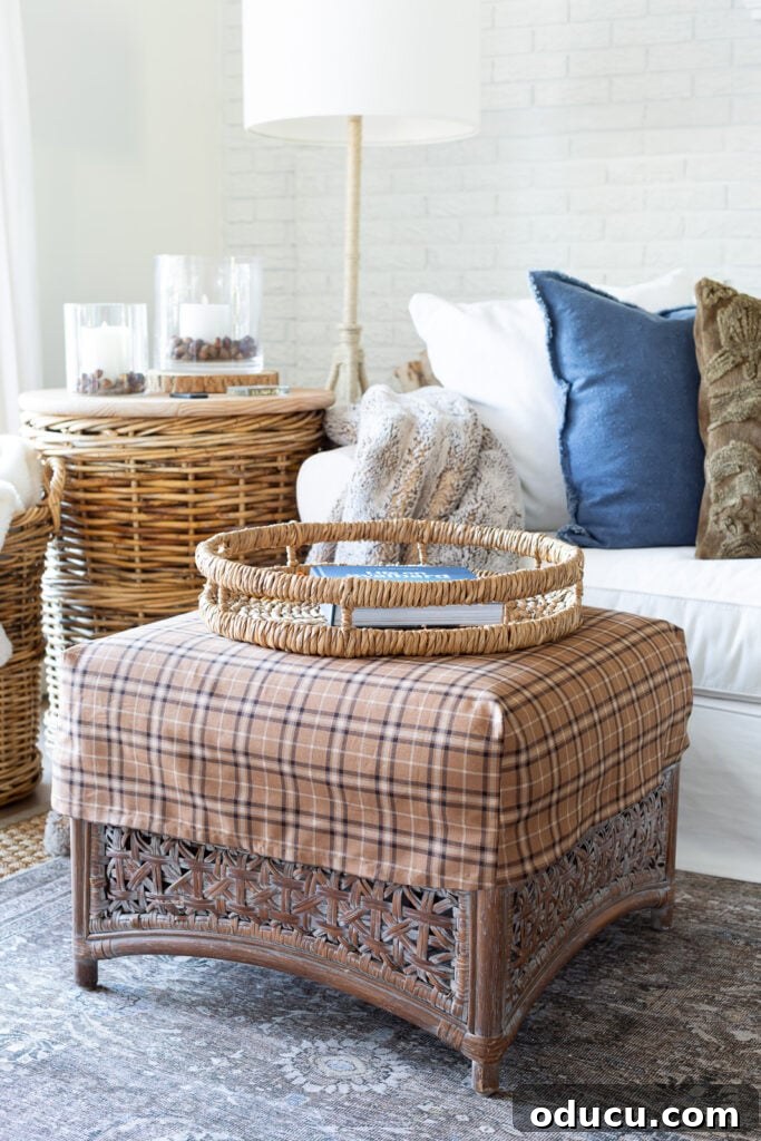 Remember That Essential Decorating Resource 8 a square rattan ottoman with a brown plaid slipcover on it in from of a white sofa with layers of fall decor on it.