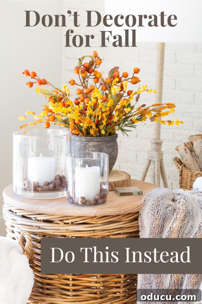 A charming vignette featuring fall flowers and glowing candles on a wicker table, with text overlay emphasizing a sensory approach to fall decorating: 'Don't decorate for fall, do this instead.' This image encapsulates the article's core message.