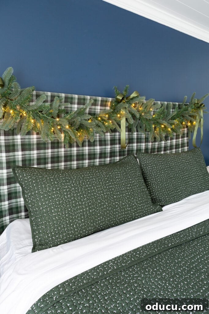 One King of Christmas Fir Set for Three Stunning Holiday Rooms 5 Bed headboard decorated for Christmas with a King of Christmas Noble Fir garland
