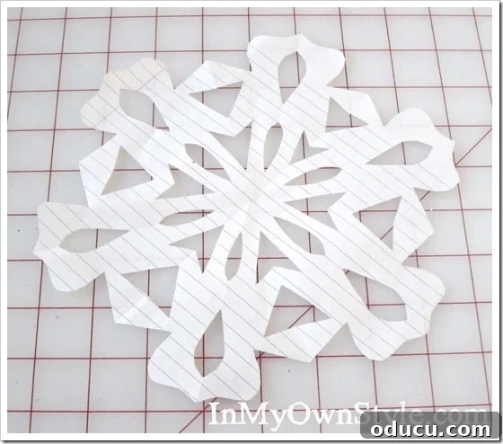 DIY Paper Snowflake Window Displays 13 A beautifully opened paper snowflake revealing its intricate design.