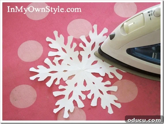 Press-each-snowflake Pressing each paper snowflake flat with an iron to remove fold lines.
