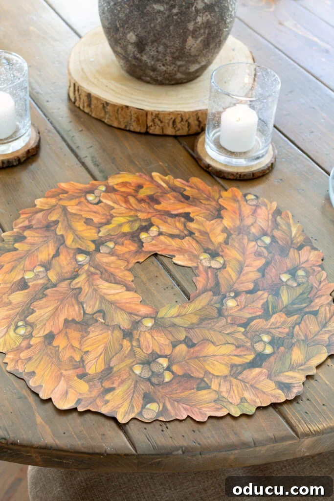 Thanksgiving's Functional and Festive Focal Point 5 A single 'Autumn Wreath' paper placemat by Hester & Cook beautifully laid on a rustic fall dinner table, ready for a plate.