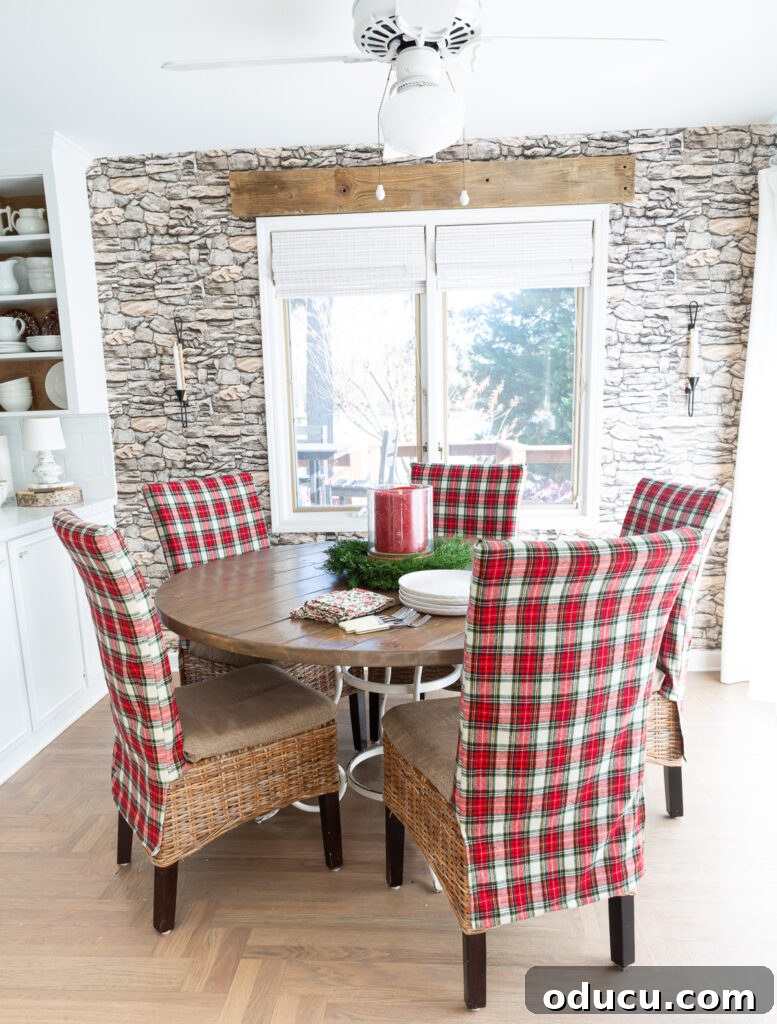 Looking at a round dining table where all the chairs are covered in a classic red and white Christmas plaid fabric.