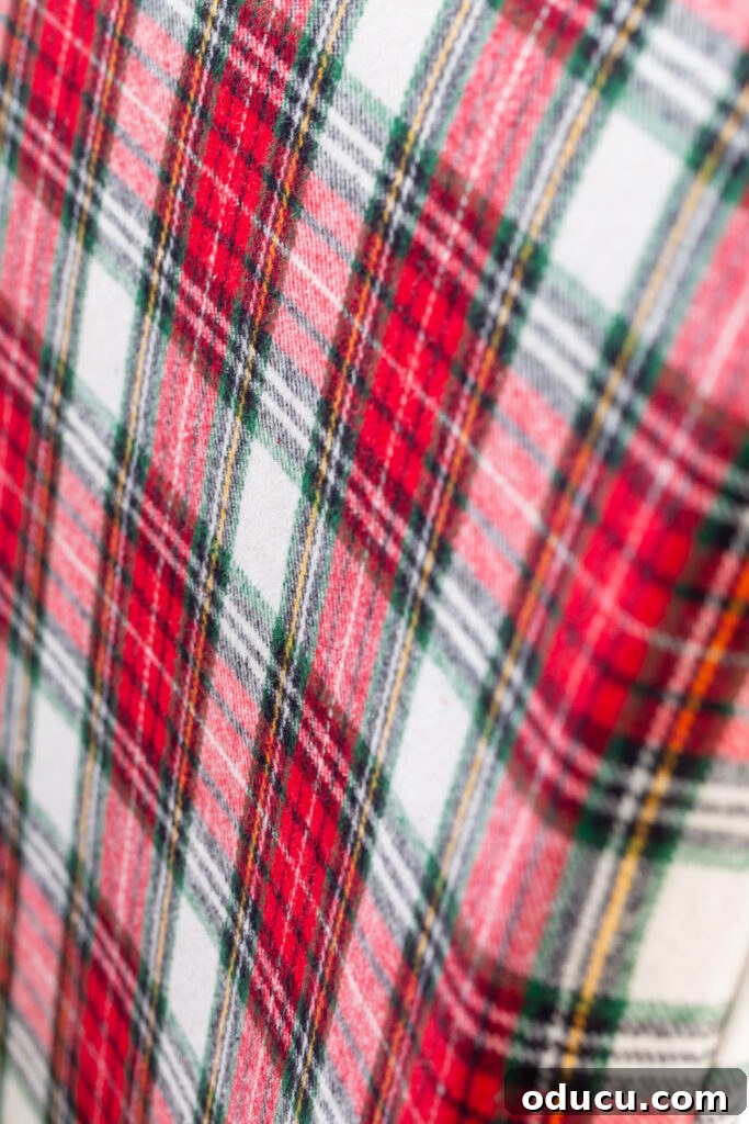close up of the red and white Christmas plaid fabric used to cover dining table chairs for the holidays.