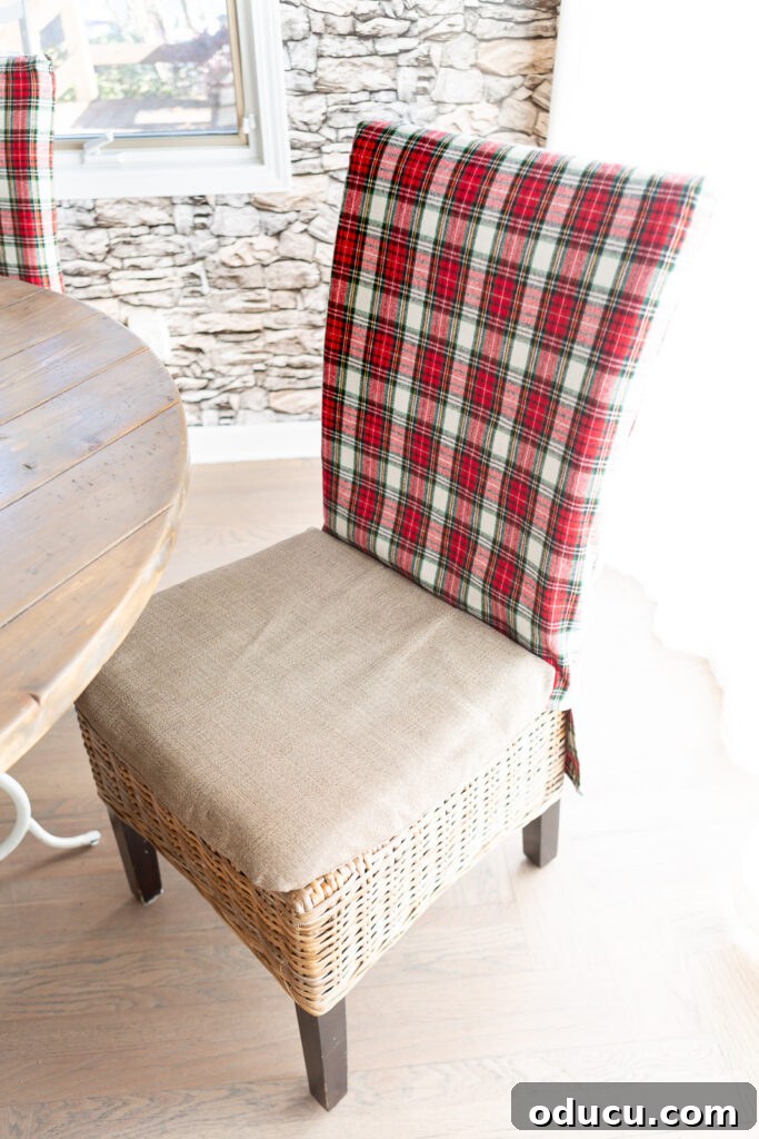 a Christmas fabric covered dining chair pulled back away from the dining table.