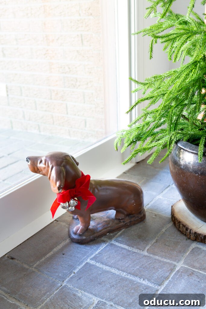 My Christmas Home: Timeless Memories, Not Trends 14 Dog statue with a red bow and jingle bells around his neck.