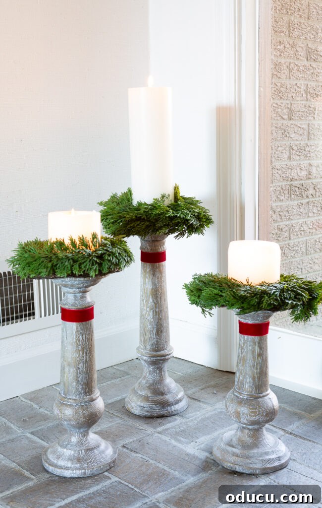 My Christmas Home: Timeless Memories, Not Trends 16 trio of large wood candle holders on floor with a wreath and red ribbon.