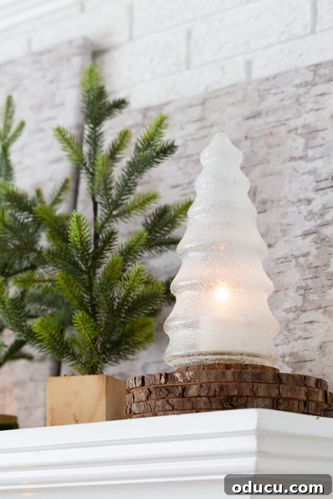 My Christmas Home: Timeless Memories, Not Trends 6 Glass and glittered Christmas tree with battery-operated candle inside on mantel.