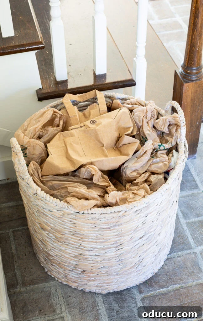 The Wreath Revelation You Need This Christmas 3 A large woven floor basket is filled with crumpled brown paper bags, forming a base for a Christmas decoration.