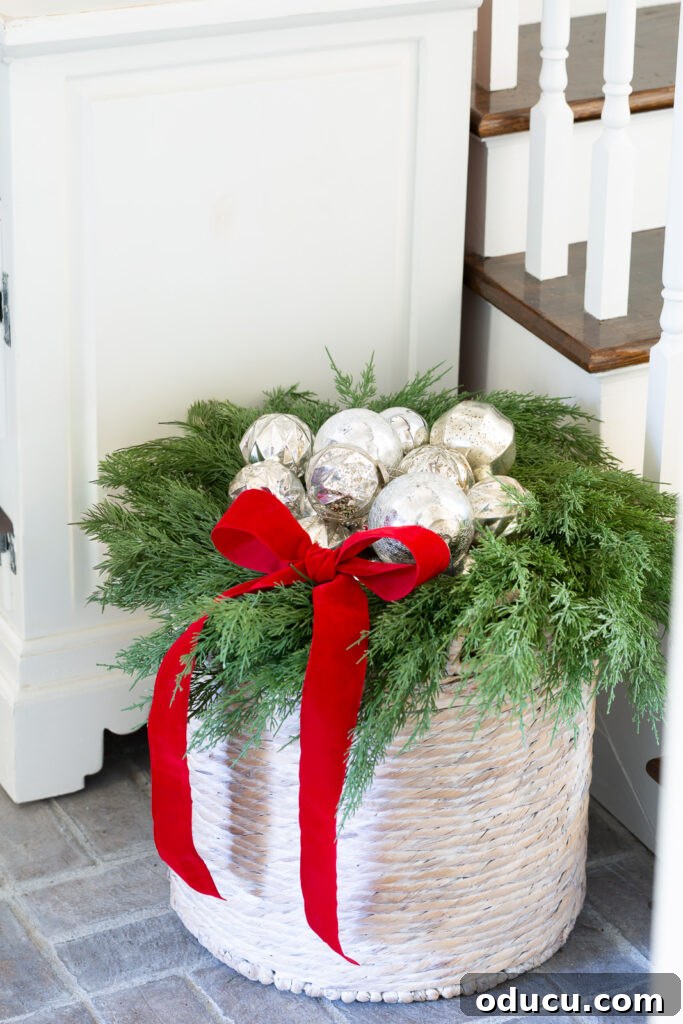 The Wreath Revelation You Need This Christmas 8 Silver Christmas ornaments are beautifully nested in a wreath on top of a large woven floor basket, creating an elegant holiday display.
