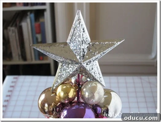 Star Tree Topper A beautiful star ornament placed securely on top of the knitting needle Christmas tree, serving as the crowning festive element.