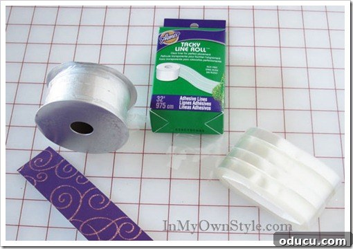 Scrapbook Paper on Ribbon Spool Scrapbook paper being carefully attached to a ribbon spool, demonstrating a step in creating a custom tree stand for a Christmas ornament tree.