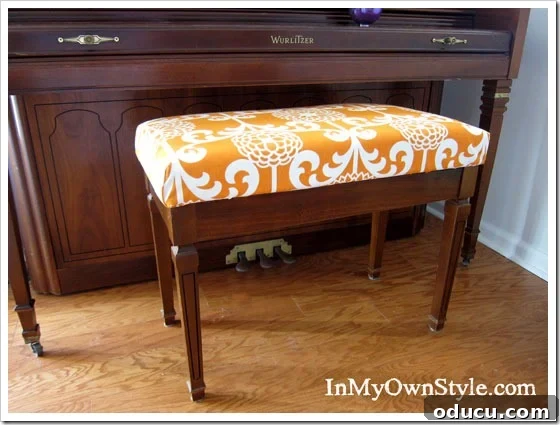 How to make a no sew fabric cushion cover for a piano bench without sewing. How to make a no sew cushion cover for a piano bench with vibrant orange fabric.