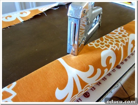 Guidance on how to properly staple fabric to cushion forms. Stapling the main decorative fabric to the bench lid, ensuring a neat, taut finish.