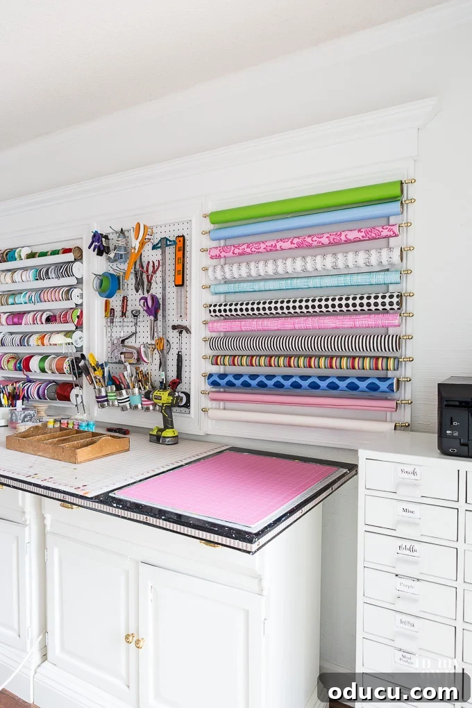 DIY Gift Wrap Storage Solution 3 Craft room showing a wall with tools, ribbon, and gift wrap neatly organized in large white frames, highlighting the modular organization system.