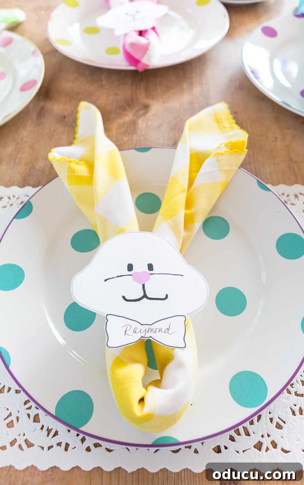 Yellow and white Bunny place card on turquoise polka dot dinner plate. Yellow and white Bunny place card on turquoise polka dot dinner plate.