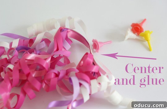 Gluing Ribbons to Candle Holder Base Close-up demonstration showing the precise method of gluing vibrant curling ribbons onto a small plastic candle holder, forming the foundational core of a festive cake topper.