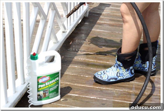 Outdoor Deck Cleaning in Progress Person Actively Cleaning Outdoor Deck Railings with a Cleaning Solution