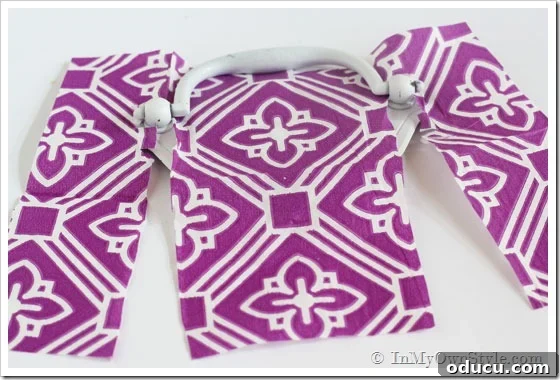 Glue-onto-pulls Furniture drawer pulls getting covered in a purple and white paper napkin, showing application
