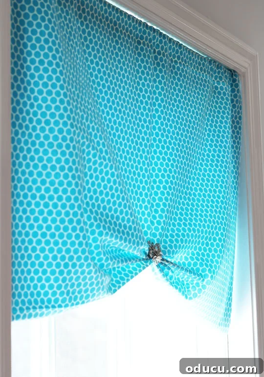 Easy Window Treatment Ideas: No-Sew Window Shade with a central brooch acting as a decorative clip.