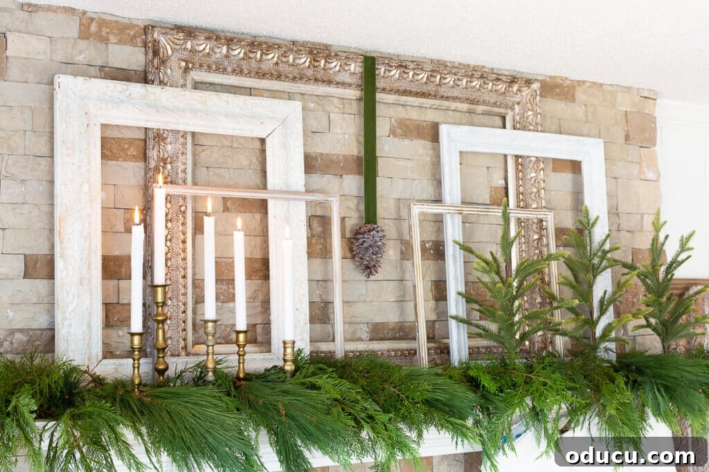 Christmas mantel decorated using 5 frames of various sizes - greenery and candles.